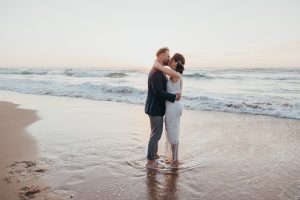 A couple kissing pose for beach wedding in portugal