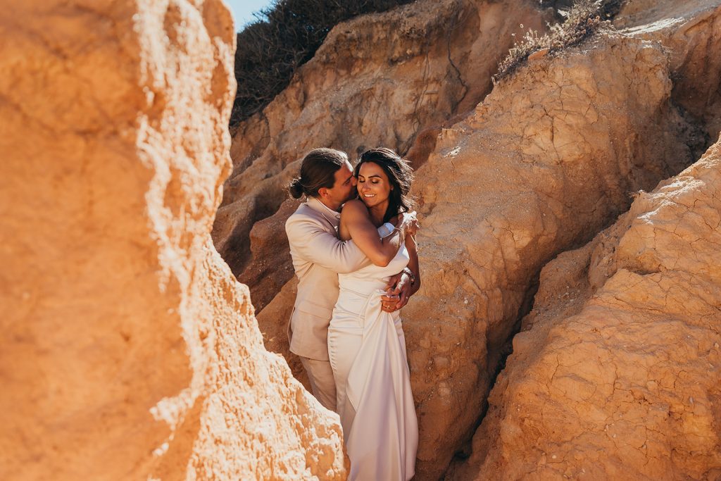 A cozy couple poses for their destination wedding